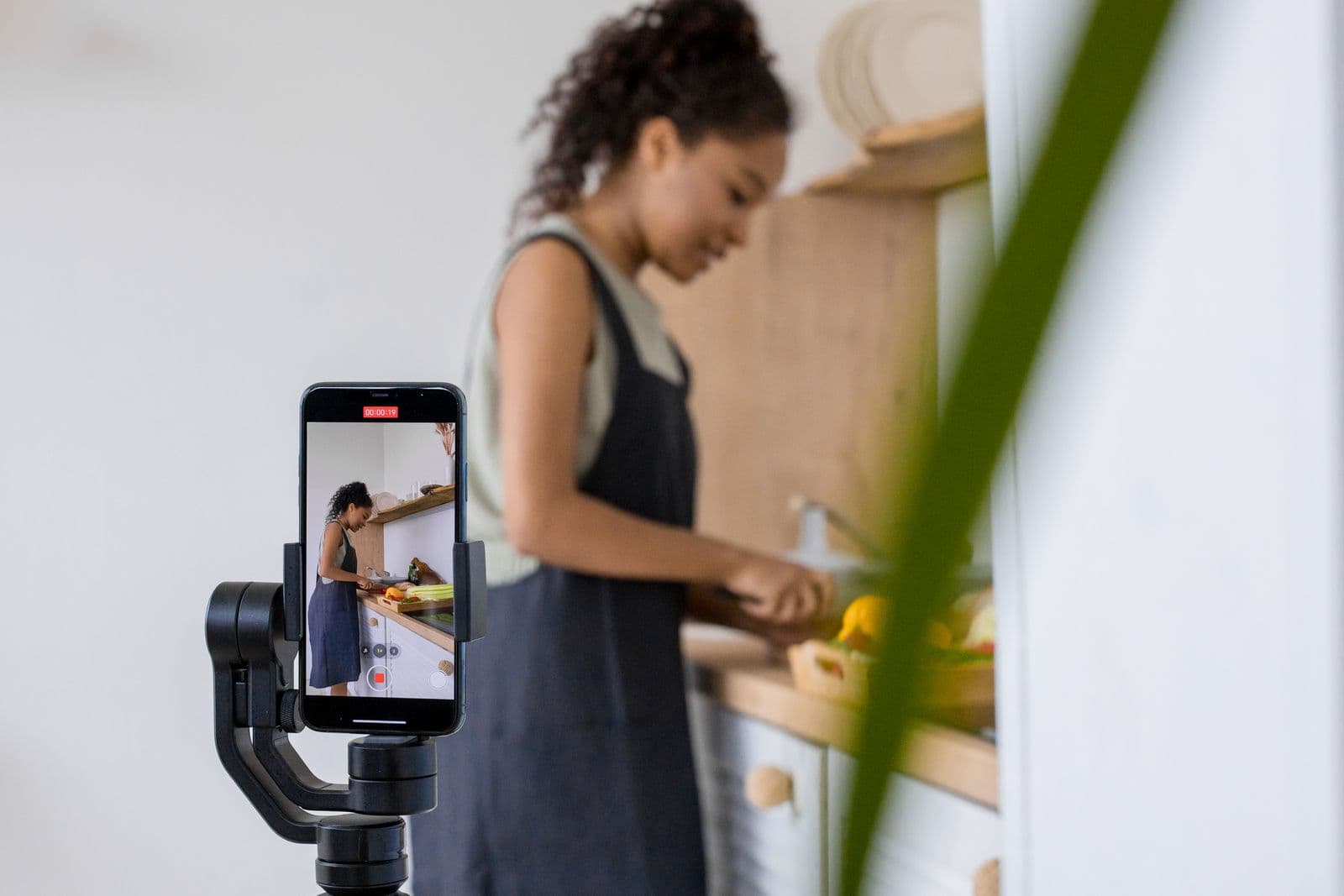 Someone cooking while a phone on a gimbal films them
