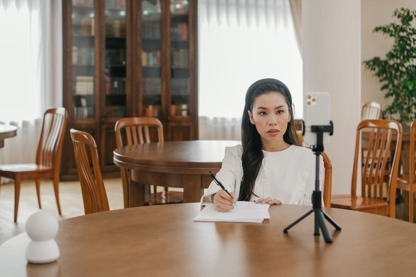삼각대에 세운 휴대폰으로 영상을 찍는 사람