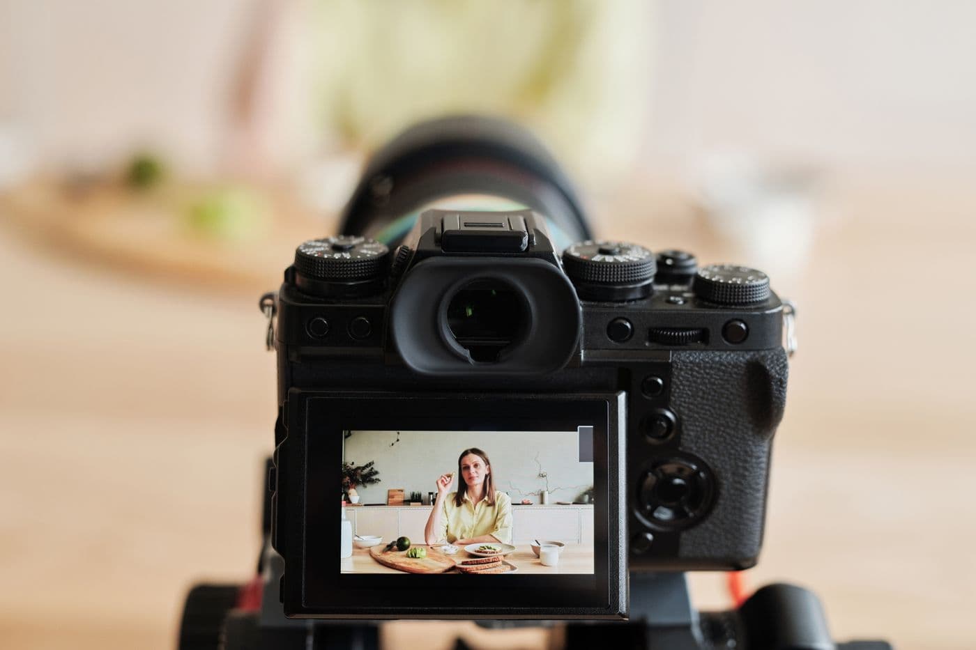 A woman recording a cooking video in her kitchen