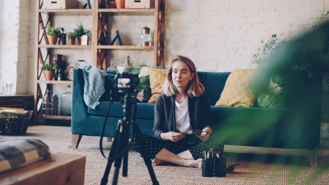 A woman filming a video at home with a camera setup